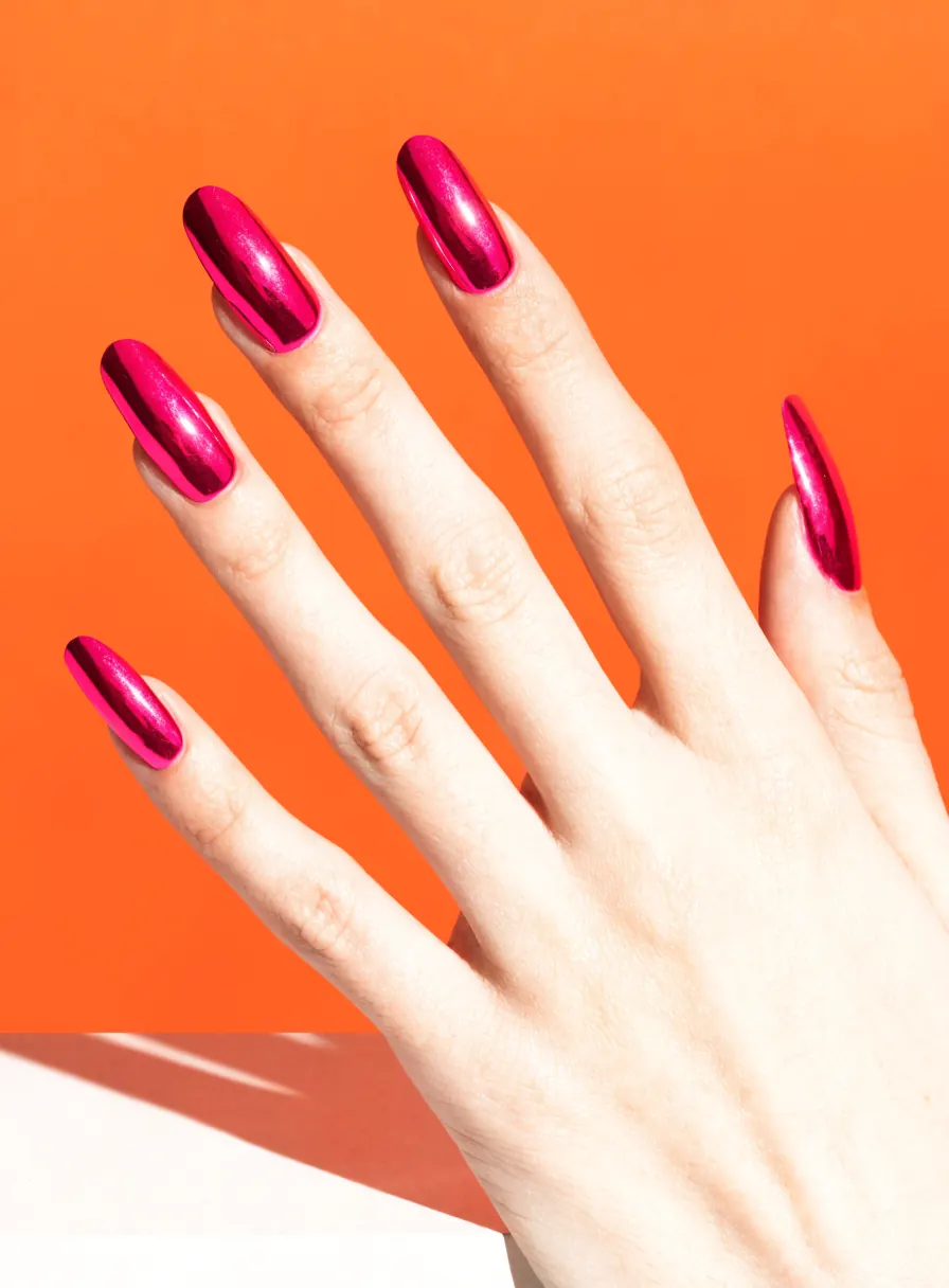 Hand with hot pink chrome mirror-finish nails