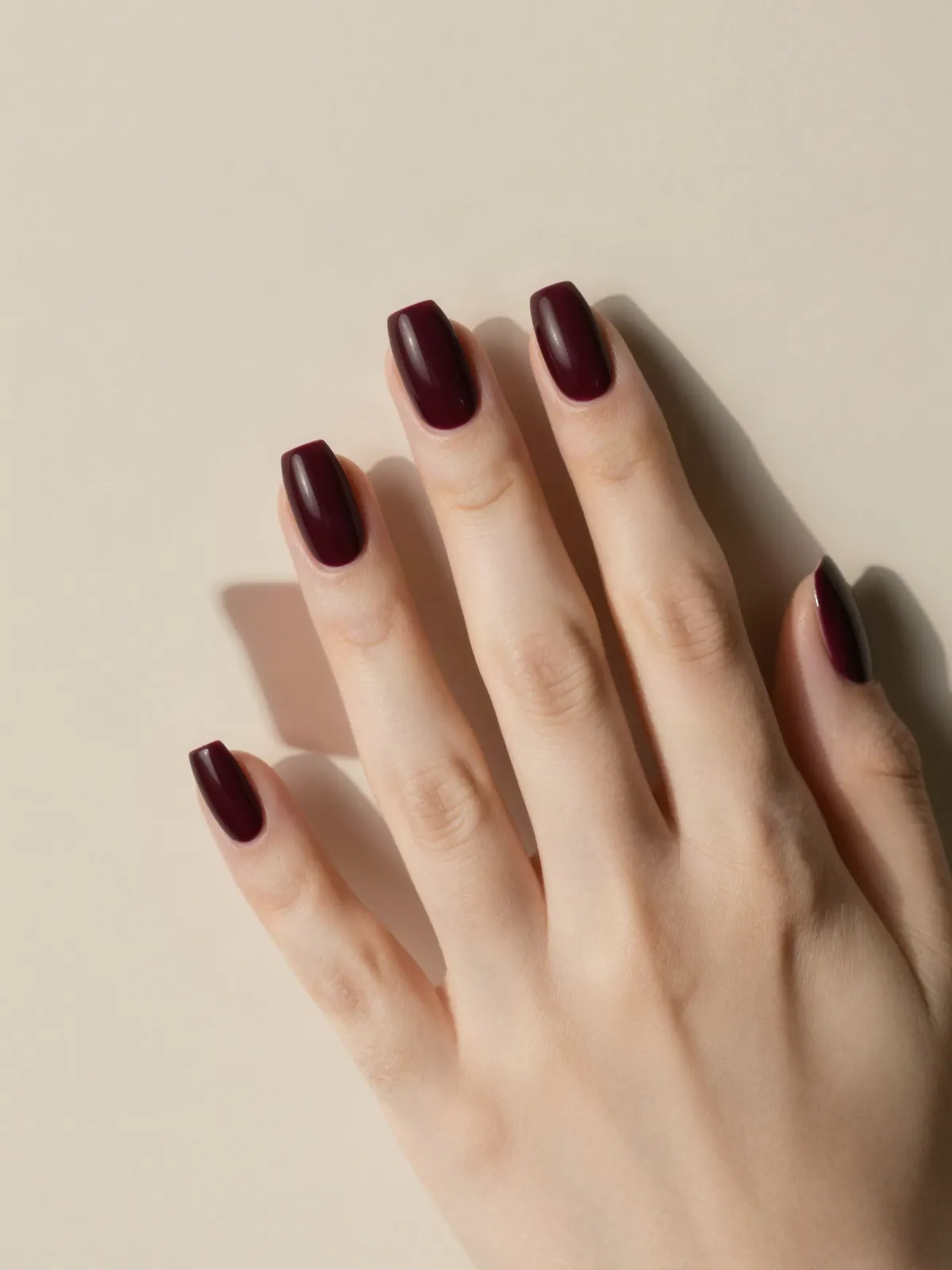 Short almond nails in a matte black-cherry burgundy