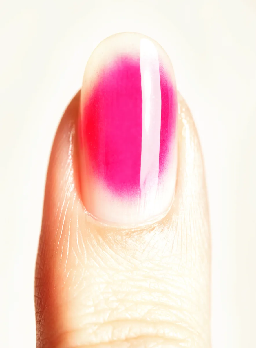 Macro close-up of an aura nail with a hot pink halo